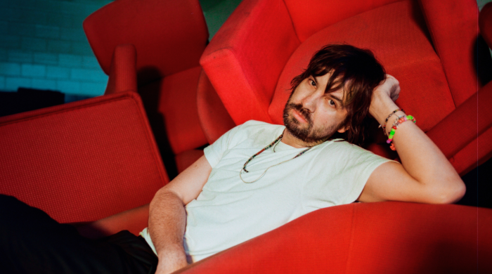 Artist Tame Impala on a red chair